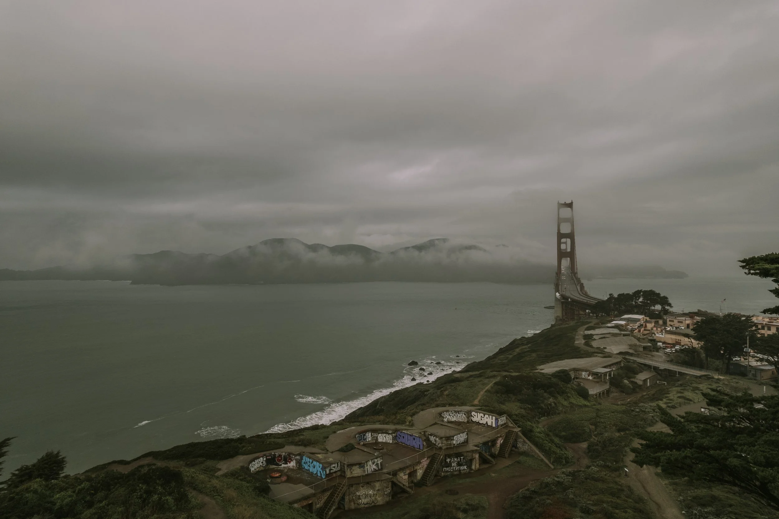 Golden Gate Bridge under low fog seen from the headlands during a San Francisco engagement session