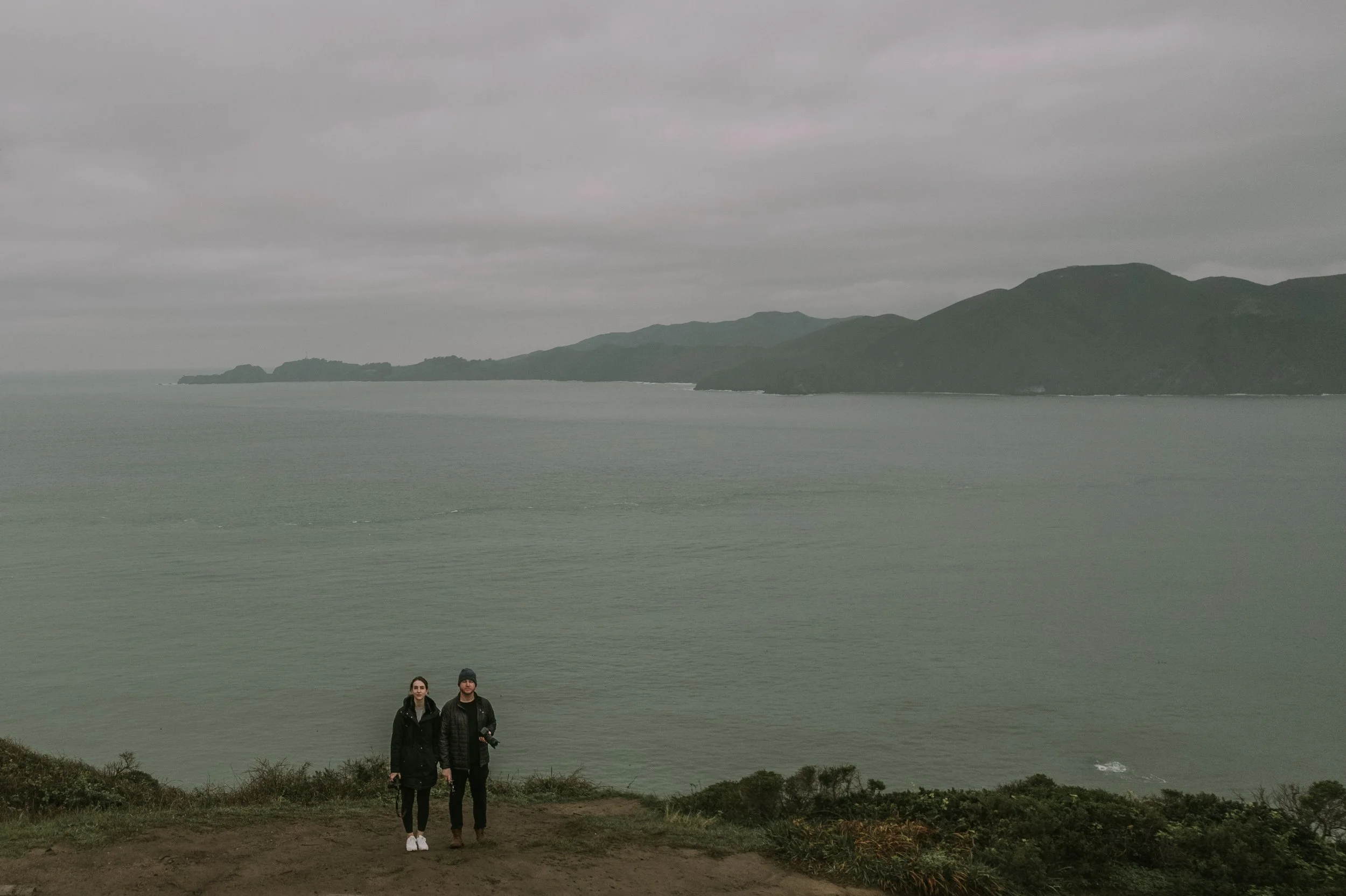 Couple stands on the cliffs above the Pacific during a San Francisco engagement session