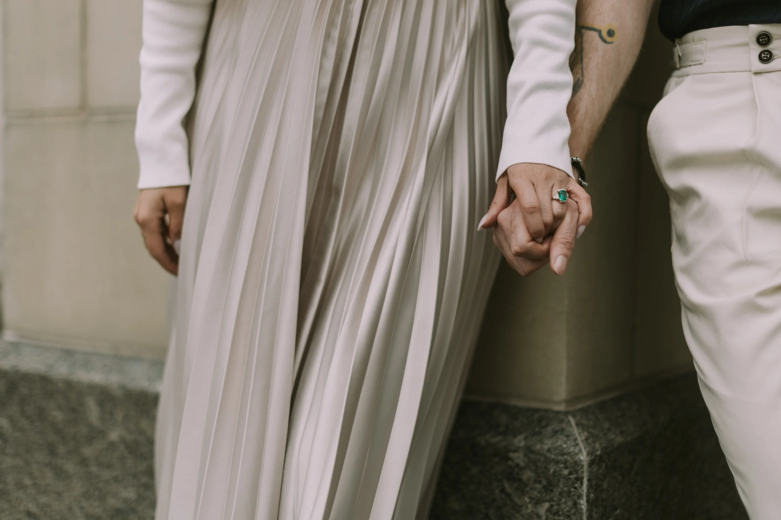 Held hands and an emerald engagement ring, pleated champagne dress, Fort Worth engagement session
